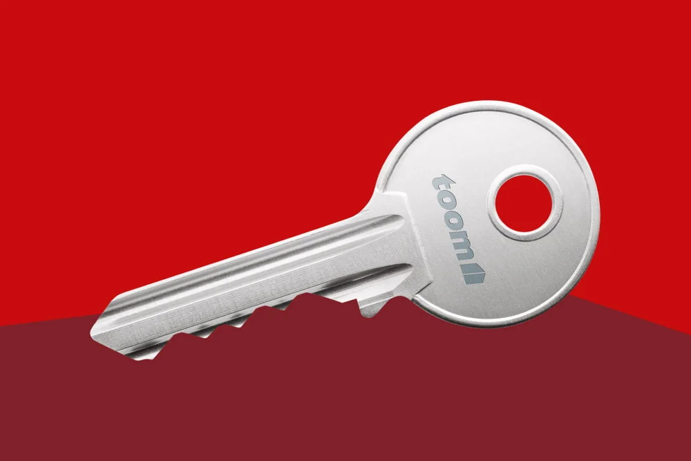 Nahaufnahme eines silbernen Schlüssels vor einem zweifarbigen roten Hintergrund.